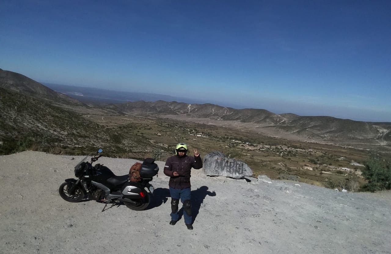 Motociclista y motocicleta frente al paisaje de Real de Catorce